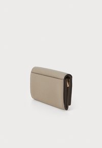 Portafoglio in pelle beige con superficie testurizzata, forma rettangolare e interno in marrone scuro a contrasto. Presenta una zip dorata e cuciture minime.