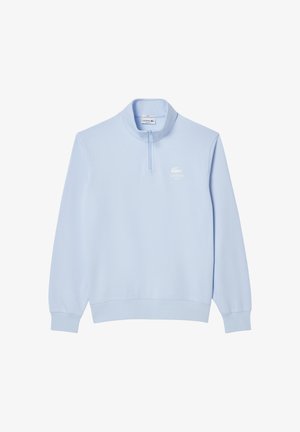 Lichtblauwe ritsloze sweatshirt met een hoge kraag, gemaakt van zacht materiaal. Heeft een wit Lacoste-logo op de linkerkant van de borst. Lange mouwen.