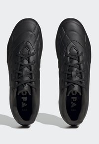 Zapatillas deportivas de cuero negro con un patrón acolchado, punta redonda y cordones negros. Presentan un interior acolchado y un logo en la plantilla.