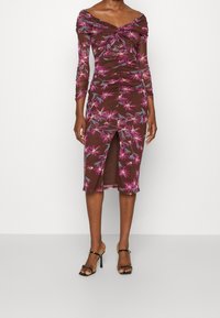 Vestido floral marrón con mangas largas, diseño fruncido, escote fuera del hombro y abertura lateral, con acentos de flores moradas y azules.