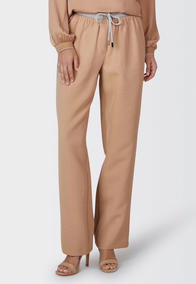 Beige wide-leg trousers with an elastic waistband and gray drawstring. Features two front pockets and a smooth texture.