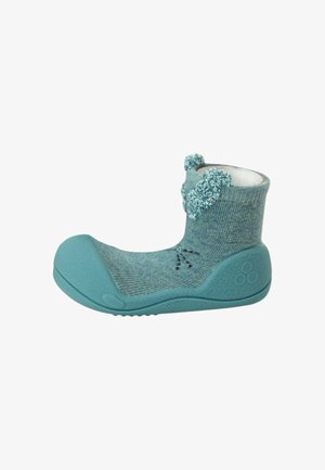 Morbida scarpa turchese per bambino con suola in gomma flessibile e tomaia lavorata a maglia con pon pon e baffi ricamati.