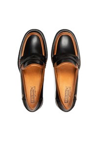 Mocasines de cuero negro con acentos marrones, punta redondeada y costuras contrastantes. Presentan una textura suave y un diseño de fácil calzado.