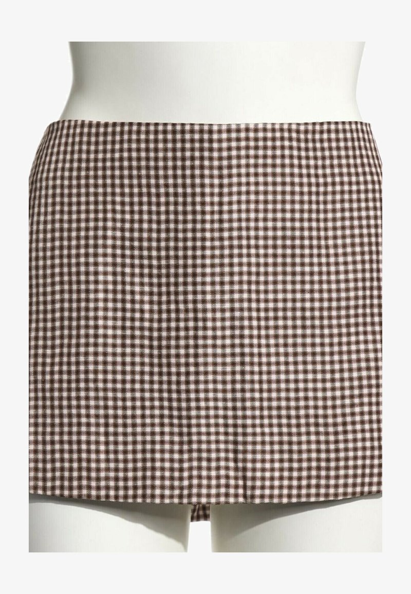 Mini-jupe à carreaux marron et blanc sur un mannequin blanc, coupe droite sans détails visibles ni ornements.