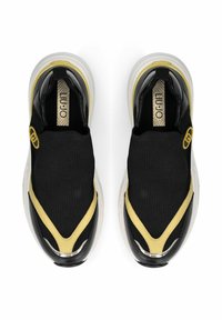 Baskets à enfiler en maille noire avec accents jaunes, superpositions noires brillantes et semelle translucide. Présentent une étiquette texturée.