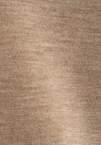 Beiger Strickstoff mit einer glatten Textur, der ein gleichmäßiges Muster und eine consistente Farbvariation über die gesamte Oberfläche aufweist.