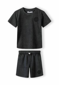 Svarta korta bomullsbyxor och t-shirt-set med korta ärmar, elastisk midja, sidofickor och en cirkulär grafik på bröstet och byxorna.
