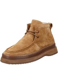 Braune Wildleder-Stiefeletten mit runder Zehenform, Schnürdesign und einer dicken braunen Gummisohle. Besitzt sichtbare Nähte und eine glatte Textur.