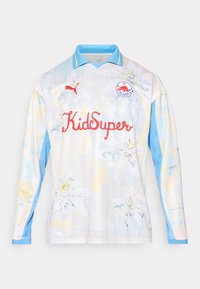 Maglia da calcio a maniche lunghe in colori chiari con stampa floreale. Presenta un colletto azzurro chiaro, il testo rosso "KidSuper" e un logo sul petto.