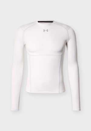 Fehér, hosszú ujjú kompressziós póló, az Under Armour logójával a mellkason, atlétikai teljesítményre és nedvességkezelésre tervezve.