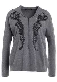Sudadera gris hecha de una tela suave que cuenta con un intrincado bordado negro en un patrón en espiral en la parte delantera, con una apertura con cremallera.