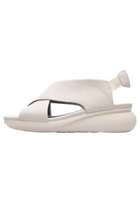 Sandali aperti in pelle bianca con un design incrociato, suola piatta e imbottita, e una cinghia posteriore per supporto.