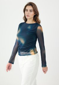 Top a maniche lunghe in rete blu scuro con accenti arancioni e gialli. Presenta una scollatura rotonda, un design arricciato ai lati e maniche trasparenti.