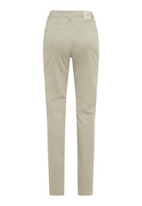 Pantalons beiges en tissu doux, avec une coupe slim, des poches arrière et une étiquette brodée à la taille. Le design est simple et classique.