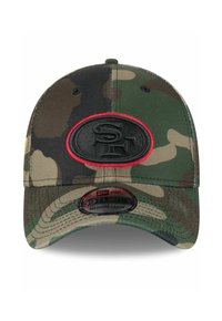 Camo-Cap aus Stoff, mit einem schwarzen Logo-Patch, das in Rot umrandet ist. Der Schirm ist leicht gebogen und weist sichtbare Nähte auf.