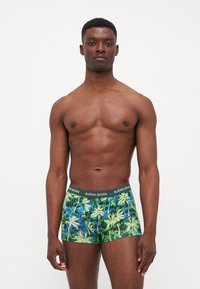 Boxershorts mit einem lebhaften Palmenmuster in Grün und Blau, mit einem dunkelgrünen Bund, der mit "BJÖRN BORG" beschriftet ist.