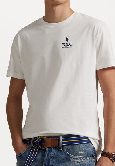 Tricou alb din bumbac cu mâneci scurte, având un logo al mărcii "Polo Ralph Lauren" de culoare albastru marin și un emblema cu un cal pe piept.