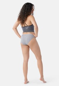 Brasile sportivo grigio con un motivo geometrico, spalline nere e slip a vita alta grigi abbinati, mostrati di schiena su uno sfondo semplice.