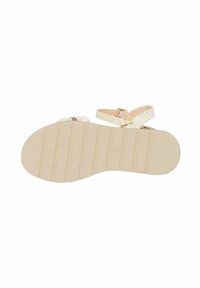 Suola di sandalo beige con grip testurizzato, caratterizzata da una cinghia decorativa intrecciata e una fibbia alla caviglia regolabile. Finitura liscia e materiale leggermente flessibile.
