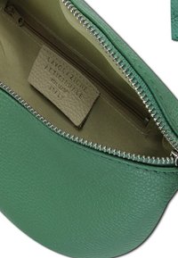 Groen leren zakje met een gestructureerde afwerking, voorzien van een zilveren ritssluiting en beige voering. Binnenin het label met de tekst "Lavorazione Artigianale Made in Italy."