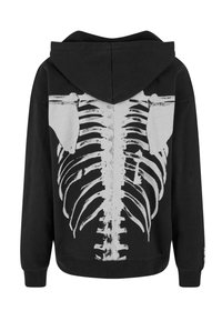 Sort hoodie med et stort hvidt skelet-ribbensgrafik på bagsiden. Lavet af blødt stof med en afslappet pasform og en frontlomme.