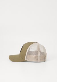 Căciulă kaki cu vizieră rotundă, spate din plasă și un patch cu logo negru. Materialul are o textură; plasă adaug�ă respirabilitate.
