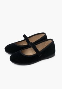 Zapatos Mary Jane de terciopelo negro con punta redonda, suela plana y una cinta de tela sobre el empeine. Forro interior suave y sin patrones visibles.
