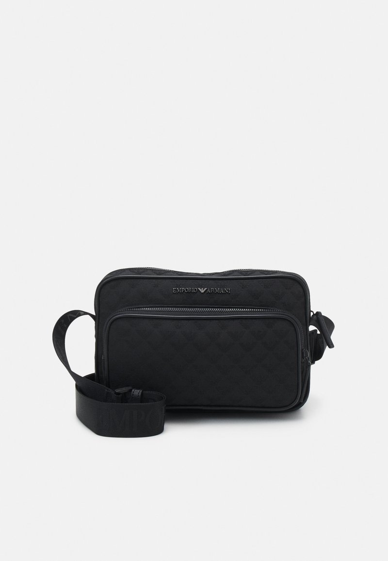 Melnas iešuvumu auduma crossbody soma ar rāvējslēdzēja aizdari, regulējamu siksnu un priekšējo kabatu. Iespējas diskretā zīmola logo sudraba krāsā.