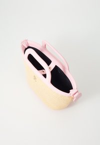 Piccola borsa a tracolla con corpo in paglia naturale intrecciata e manici in pelle rosa chiaro. Presenta accessori in oro e un interno scuro.