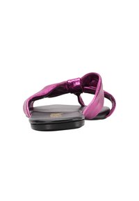 Rosa metallisk sandaler med en sløjfe-design, flad sort sål, åben tå og stropper, der danner en løkke. Glat tekstur hele vejen igennem.