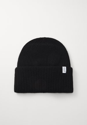 Gorra de punto negra con textura acanalada y borde doblado. Presenta una pequeña etiqueta de logotipo blanca en el lateral.