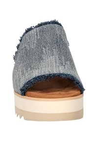 Denim instaplaars in lichtblauw met rafelige randen, open teen, tan voetbed en een dikke witte platformzool.
