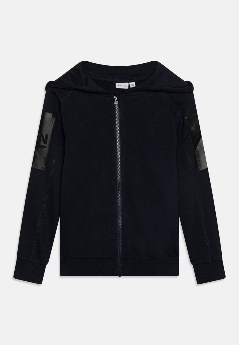Felpa con zip color navy realizzata in tessuto morbido, con un ampio cappuccio, polsini a costine e dettagli neri lucidi sulle maniche con un numero.