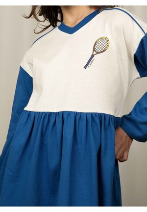 Robe bleue et blanche avec une taille froncée, présentant un motif d'une raquette de tennis sur la poitrine et des manches bleues contrastantes. Matière en coton douce.