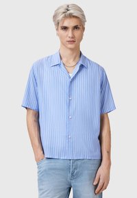 Camicia azzurra a maniche corte con bottoni, a righe bianche verticali, colletto classico e vestibilità rilassata. Tessuto di trama liscia.