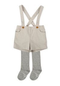 Shorts à carreaux beiges avec bretelles croisées, dotés de deux boutons marron et de collants en tricot gris en dessous. Tissu texturé avec poches.