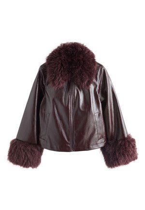 Veste en cuir brillante foncée avec grand col en fourrure duveteuse et poignets en fourrure assortis sur manches longues, fermeture éclair frontale.