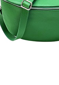 Groene leren crossbody tas met een rond ontwerp, textuur oppervlak, zilveren rits en verstelbare schouderriem.