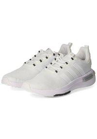 White athletic shoes made of mesh fabric with a textured surface, featuring three black stripes, lace closure, and a cushioned sole.