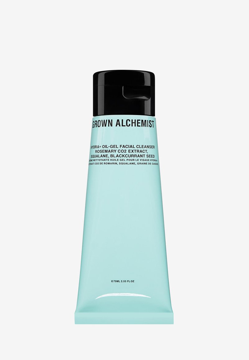 Akvablu tub med svart flip-top lock. Texten innehåller produktnamn och ingredienser. Snygg, cylindrisk form med matt yta.