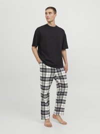 Svart bomullst-shirt med kort ärm i kombination med pyjamasbyxor i vit och svart rutig bomull, med rak benmodell och mjuk textur.