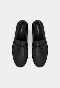 Chaussures en cuir noir à enfiler avec un bout arrondi, des coutures décoratives et une finition douce. Logo ALDO imprimé à l'intérieur de la chaussure.