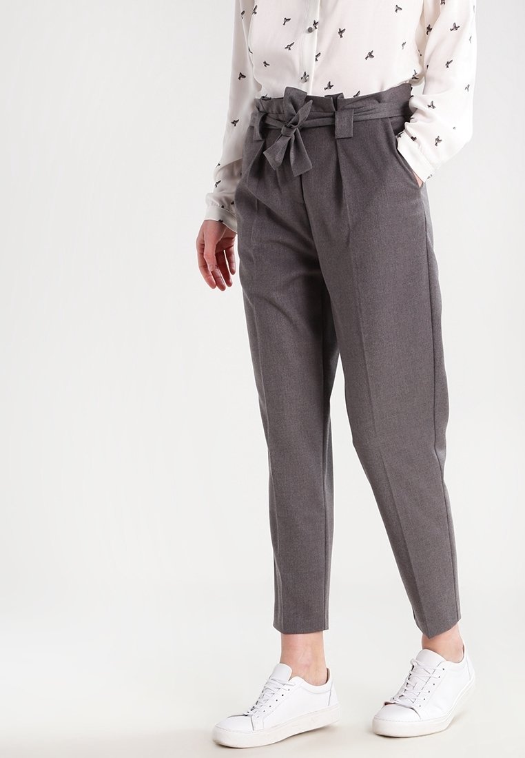 Szare dopasowane spodnie z wysokim stanem i paskiem do wiązania, z tapered nogawkami. Połączone z białą koszulą i białymi sneakersami.