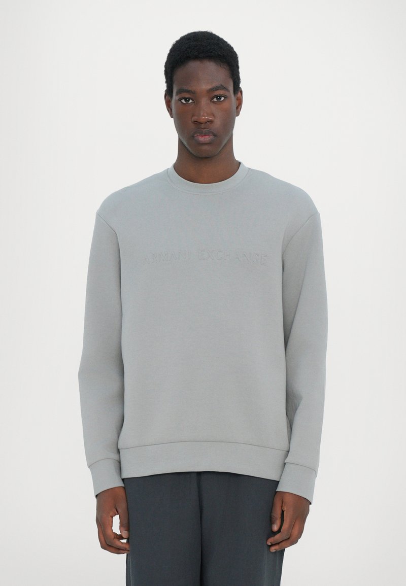 Gray sweatshirt made of soft cotton blend, featuring a crew neck, long sleeves, and embossed "Armani Exchange" logo on the front.