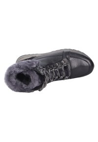 Bottine noire en cuir avec doublure en fourrure grise, design à lacets et couture texturée. Semelle en caoutchouc plate et accents en métal.