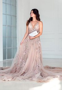 Light pink gown with a deep V-neckline, intricate floral embroidery, sheer overlay, and a flowing train. Accessory: light-blue clutch.