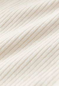 Hellbeige, strukturierter Stoff mit vertikalen Rippungen, weich im Griff, mit einem sanften Glanz und einem flauschigen Finish.