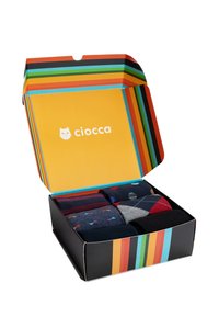 Scatola regalo colorata contenente sei paia di calzini con vari motivi, tra cui pois e argyle. La scatola ha un interno giallo e rifiniture a righe.