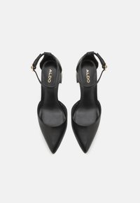 Black leather high-heeled shoes with pointed toes, ankle strap, and textured detail on the strap. Brand name "ALDO" visible inside.
