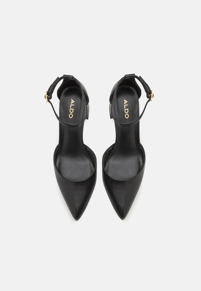 Scarpe con tacco alto in pelle nera, con punte appuntite, cinturino alla caviglia e dettaglio testurizzato sul cinturino. Nome del marchio "ALDO" visibile all'interno.